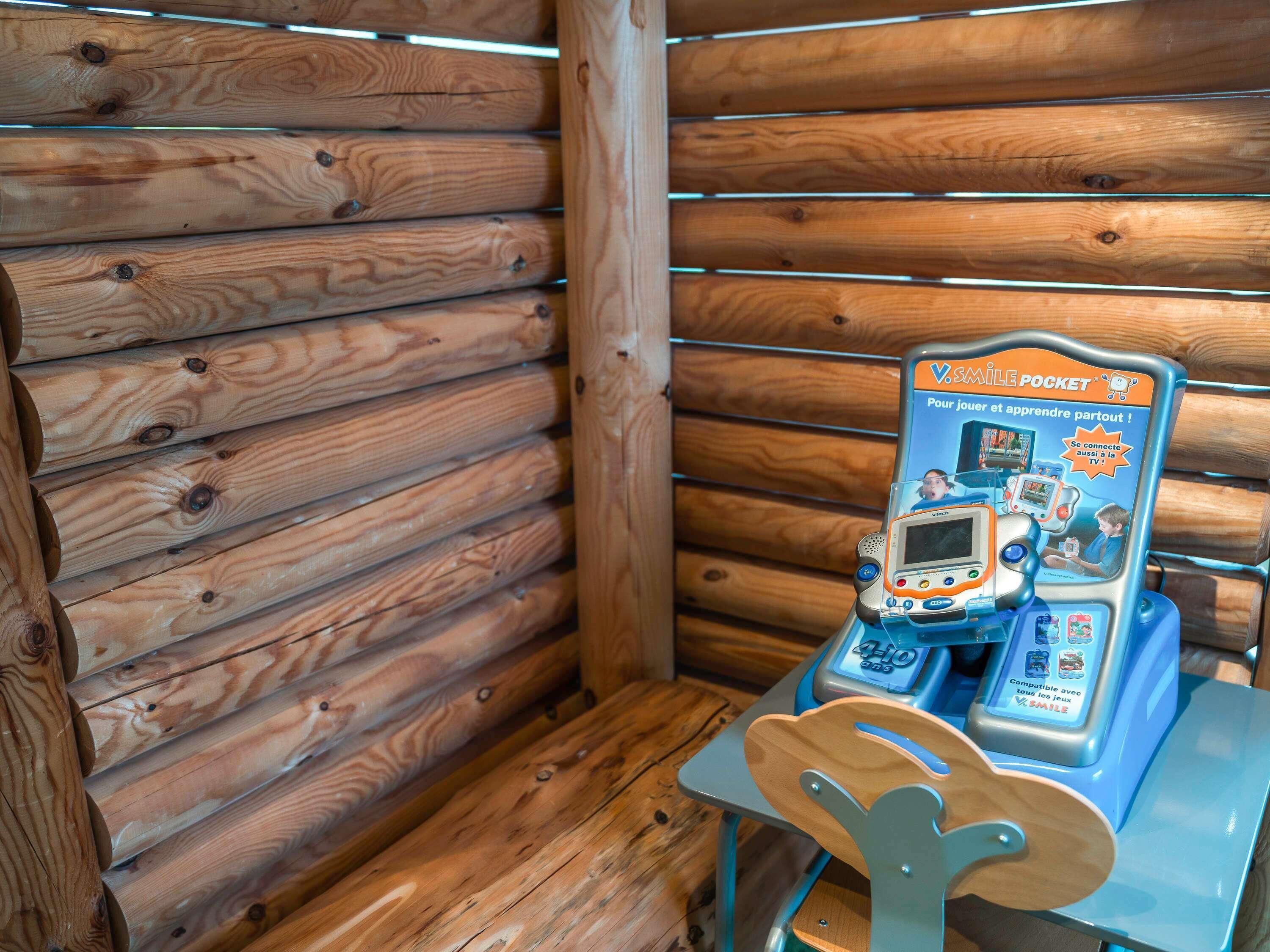 A wooden cabin interior with a table and a children's learning game device.
