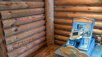 A wooden cabin interior with a table and a children's learning game device.