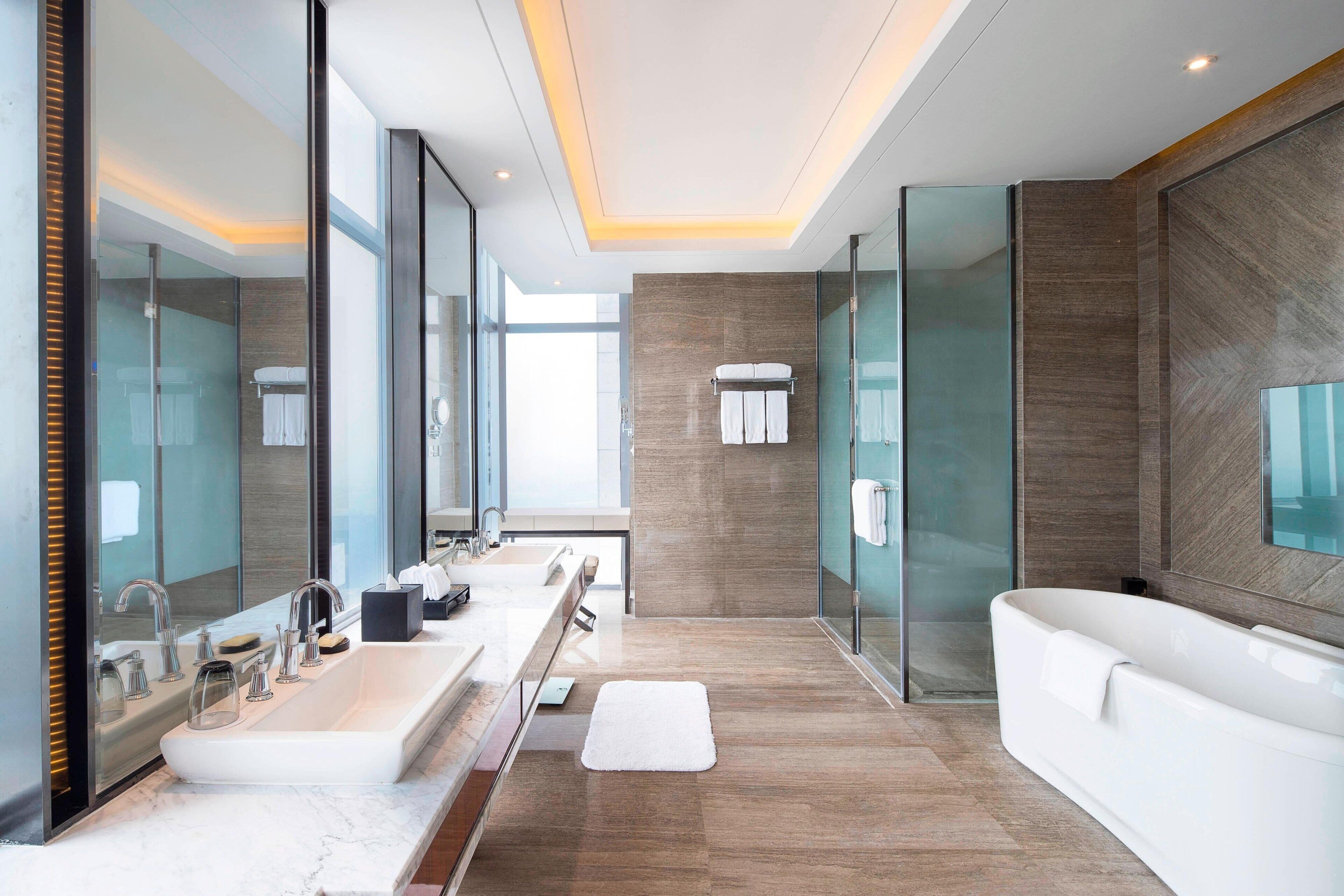 A modern bathroom with a large sink, mirror, and bathtub.