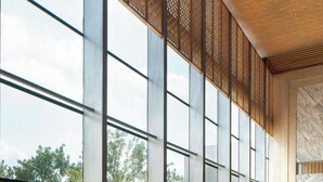 Un vestíbulo amplio con ventanas grandes, muebles modernos y vistas al exterior.