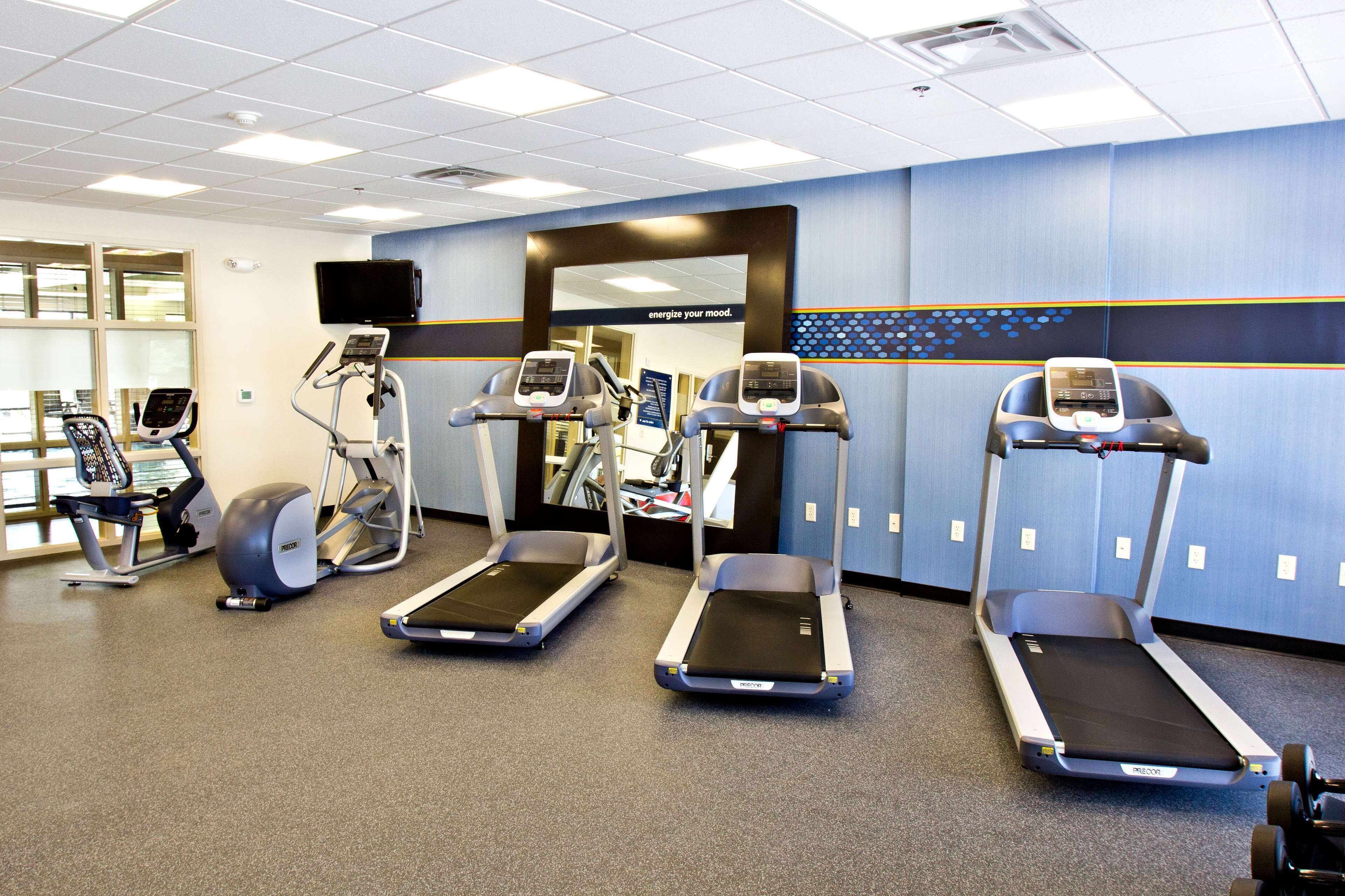 A gym with treadmills, elliptical machines, and stationary bikes.
