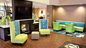 A lobby with a fireplace, seating area, and a large flat-screen TV. - Hampton Inn & Suites Salt Lake City/Farmington (Farmington)