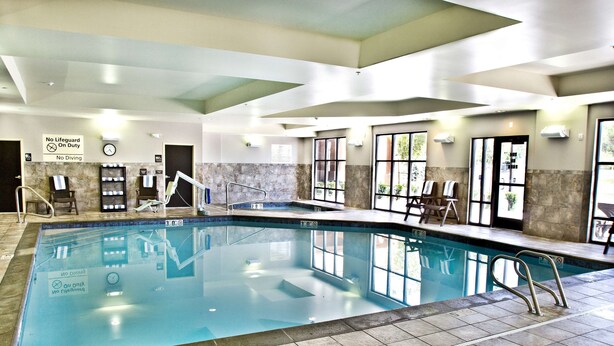 An indoor swimming pool with a tiled floor, a lifeguard chair, and a no diving sign. - Hampton Inn & Suites Salt Lake City/Farmington (Farmington)