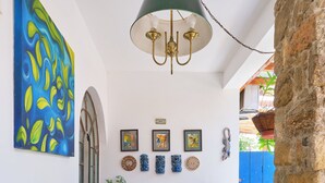 A dining area with a table, chairs, and a hanging light fixture. - Pousada Pontal Gardens (Paraty)