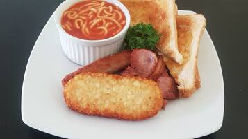 A plate with toast, sausage, and a bowl of soup.