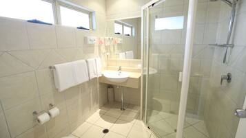 Un bagno moderno con doccia vetrata, lavandino e water.