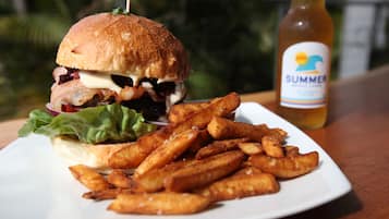 Un plato con una hamburguesa y papas fritas, y una botella de bebida Summer.