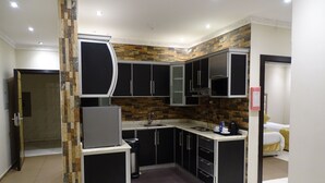 Cozinha moderna com armários pretos, forno embutido e painel de azulejos.