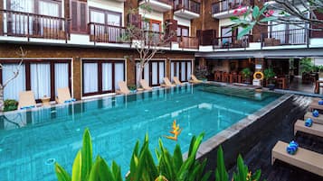 Relax by the rooftop pool surrounded by lounge chairs and lush greenery.