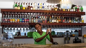 A bar area with shelves of liquor bottles and glasses. - Treasure Cove (Mahé Island)