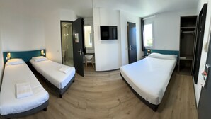 A hotel room with three single beds, a TV, a desk, and a wardrobe. - Hôtel Face West Le Pontet (Le Pontet)