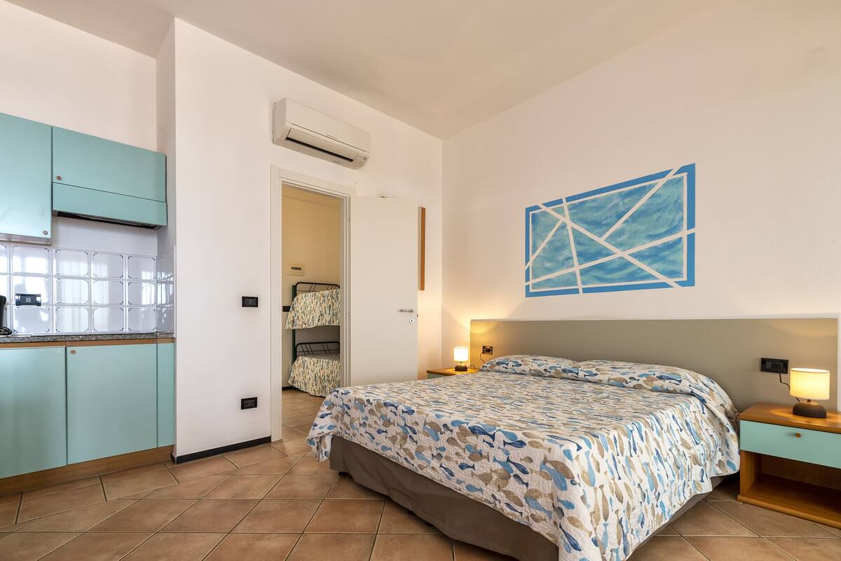 A bedroom with a bed, bedside table, and a wall-mounted artwork.
