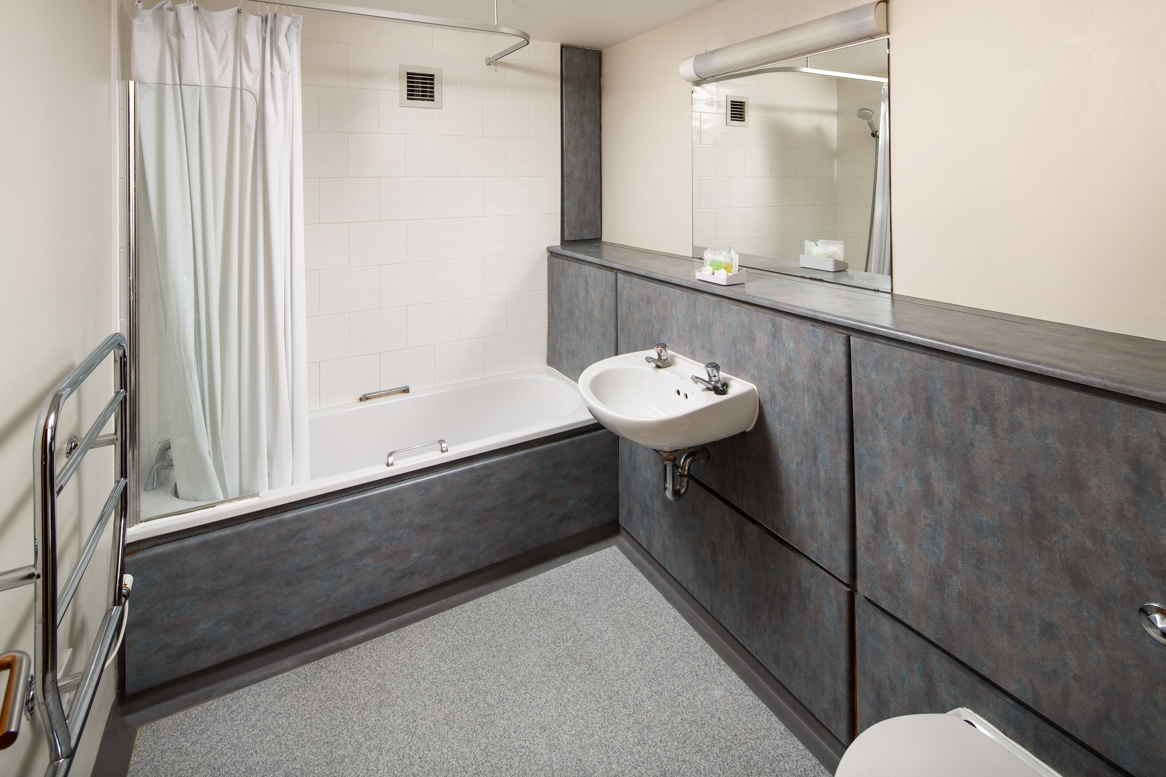 A modern bathroom with a bathtub, a sink, and a toilet.