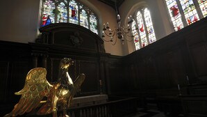 A church interior with stained glass windows, a chandelier, and a golden angel statue. - Christs College Cambridge (Cambridge)