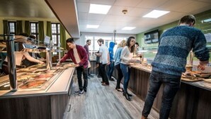A cafeteria with long tables and people eating. - Christs College Cambridge (Cambridge)