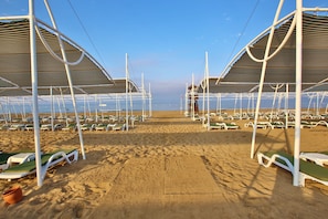 Privat strand, solstolar, parasoller och strandhanddukar