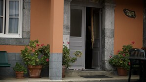 A building entrance with a door, potted plants, a bench, and a sign reading "MAISON DREYT."