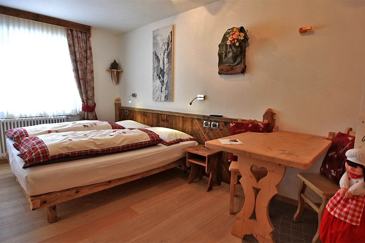 Una habitación acogedora con una cama de madera, una mesita pequeña y una decoración rústica.