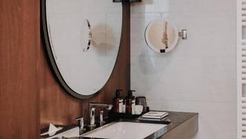 Un baño moderno con dos lavamanos, un espejo grande y un mueble de tocador de madera.