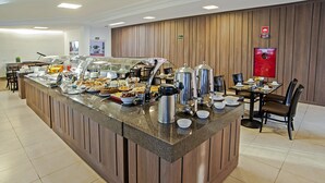 A buffet area with a variety of food items and a coffee station. - The Hill Executive (São Carlos)