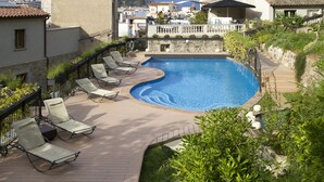 A swimming pool with lounge chairs, surrounded by greenery and overlooking a hillside. - Casa Granados Boutique Hotel (Tossa de Mar)