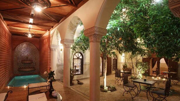 An indoor courtyard with a pool, seating areas, and decorative arches. - Riad Sidi Ayoub (Marrakech)