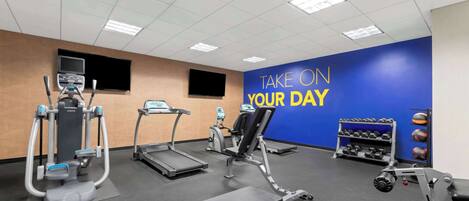 A gym with treadmills, elliptical machines, and weightlifting equipment.