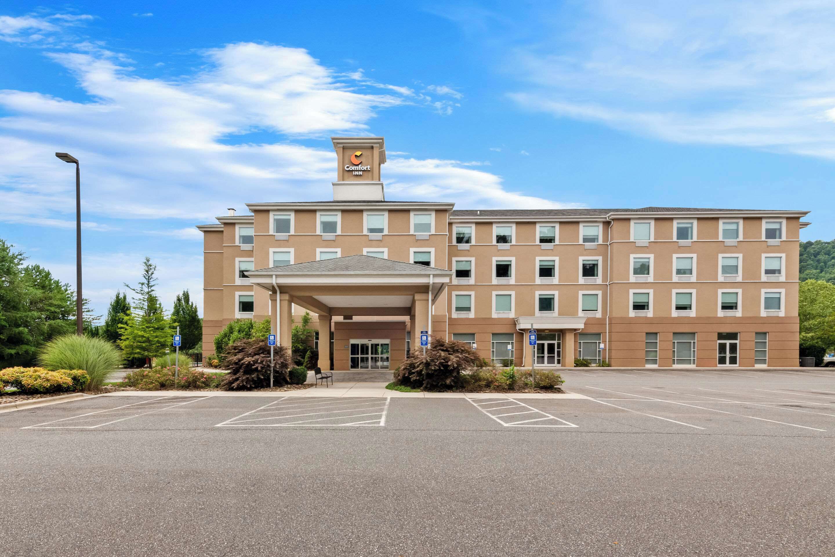 Un hôtel à plusieurs étages doté d’une entrée principale, d’un parking et d’une enseigne indiquant qu’il s’agit d’un hôtel Comfort Inn.