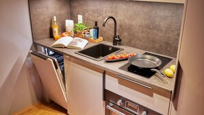 Een moderne keuken met een vaatwasser, spoelbak en inductiekookplaat.