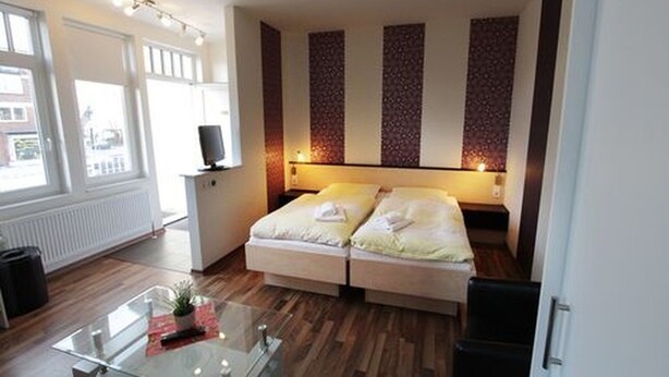 Una habitación de hotel con una cama, un escritorio y una ventana.