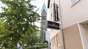 A hotel named "HOTEL am Friedensplatz" with a visible clock tower in the background. - Hotel Am Friedensplatz (Stuttgart)