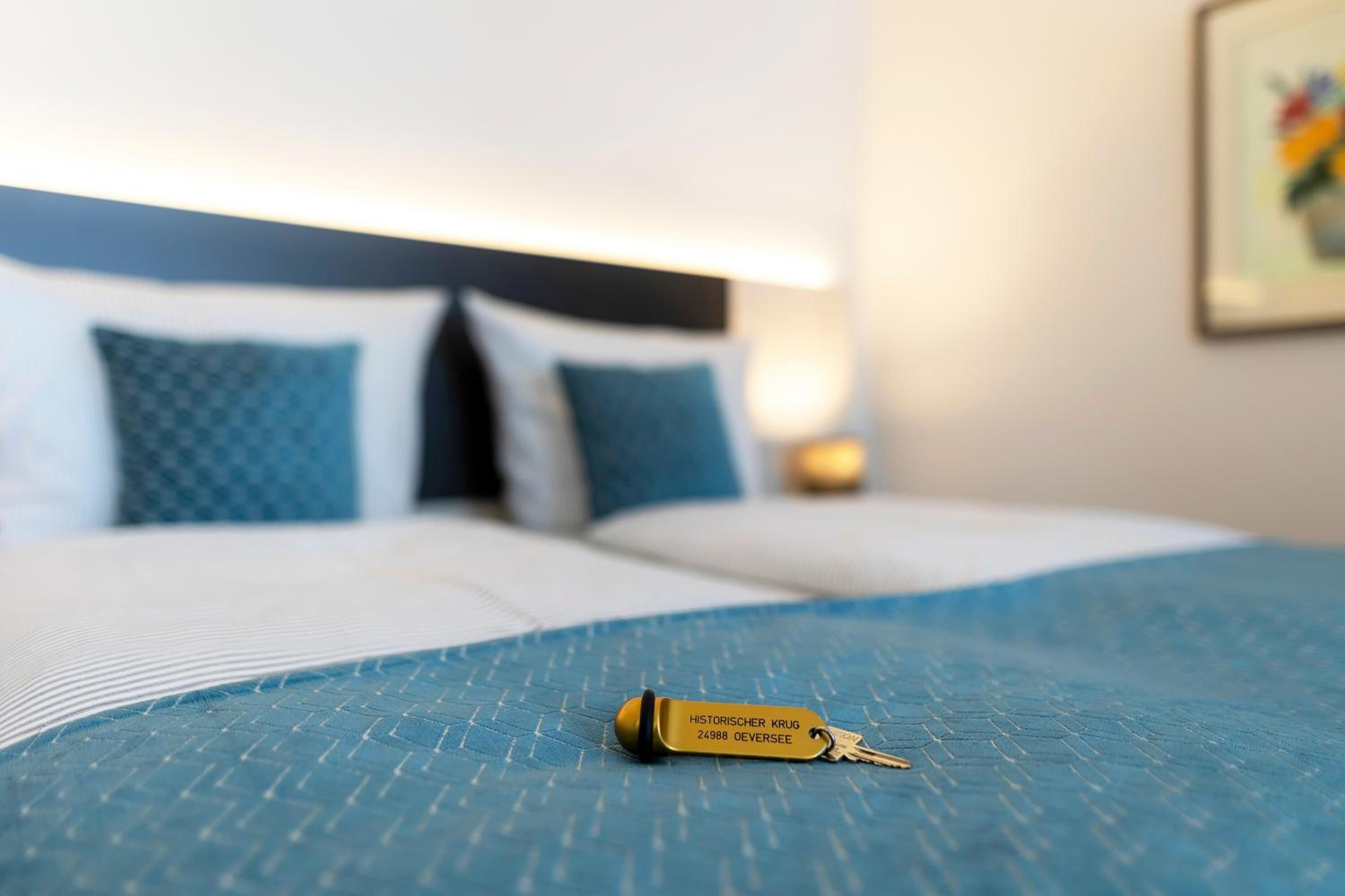 Un letto con una coperta blu e un portachiavi sopra.