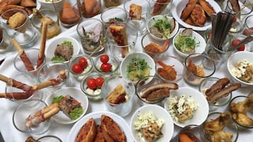 Une table sur laquelle sont disposés divers aliments et boissons, notamment de petits bols, des assiettes et des verres.
