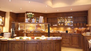 Een houten keuken met een buffetopstelling, inclusief diverse gerechten en een koffieapparaat.