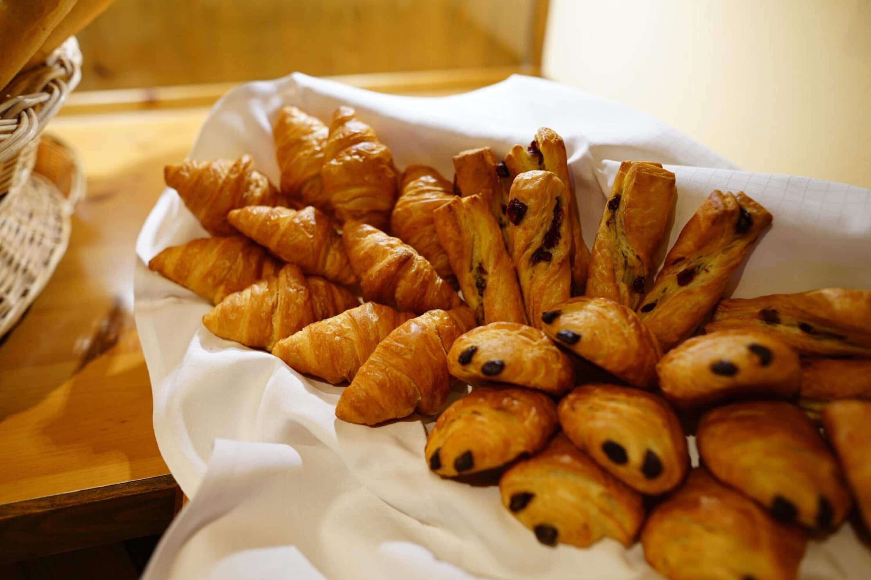 Una bandeja con diversos pasteles, incluyendo croissants y medialunas de chocolate.