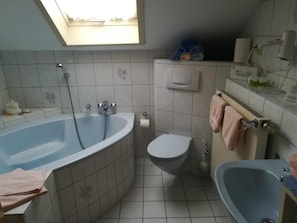 Une salle de bain avec une baignoire, des toilettes et un lavabo.
