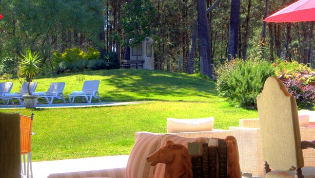 Habitación con vista a un césped cuidado y sillones de descanso.