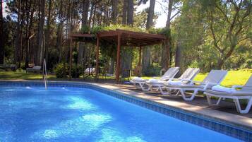 Una piscina al aire libre, tumbonas