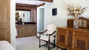 Una habitación con una silla y un armario de madera, y un espejo en la pared.