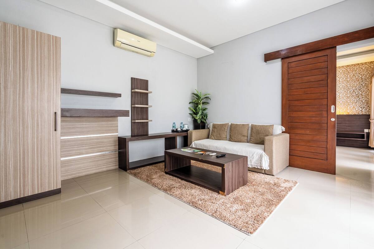 Un salon moderne avec un canapé, une table basse et une armoire en bois.