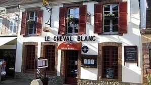 A building with the sign "LE CHEVAL BLANC" indicating a restaurant or cafe.