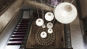 A grand staircase with ornate railings and a patterned floor. - Maison d'Anthouard (Ecully)