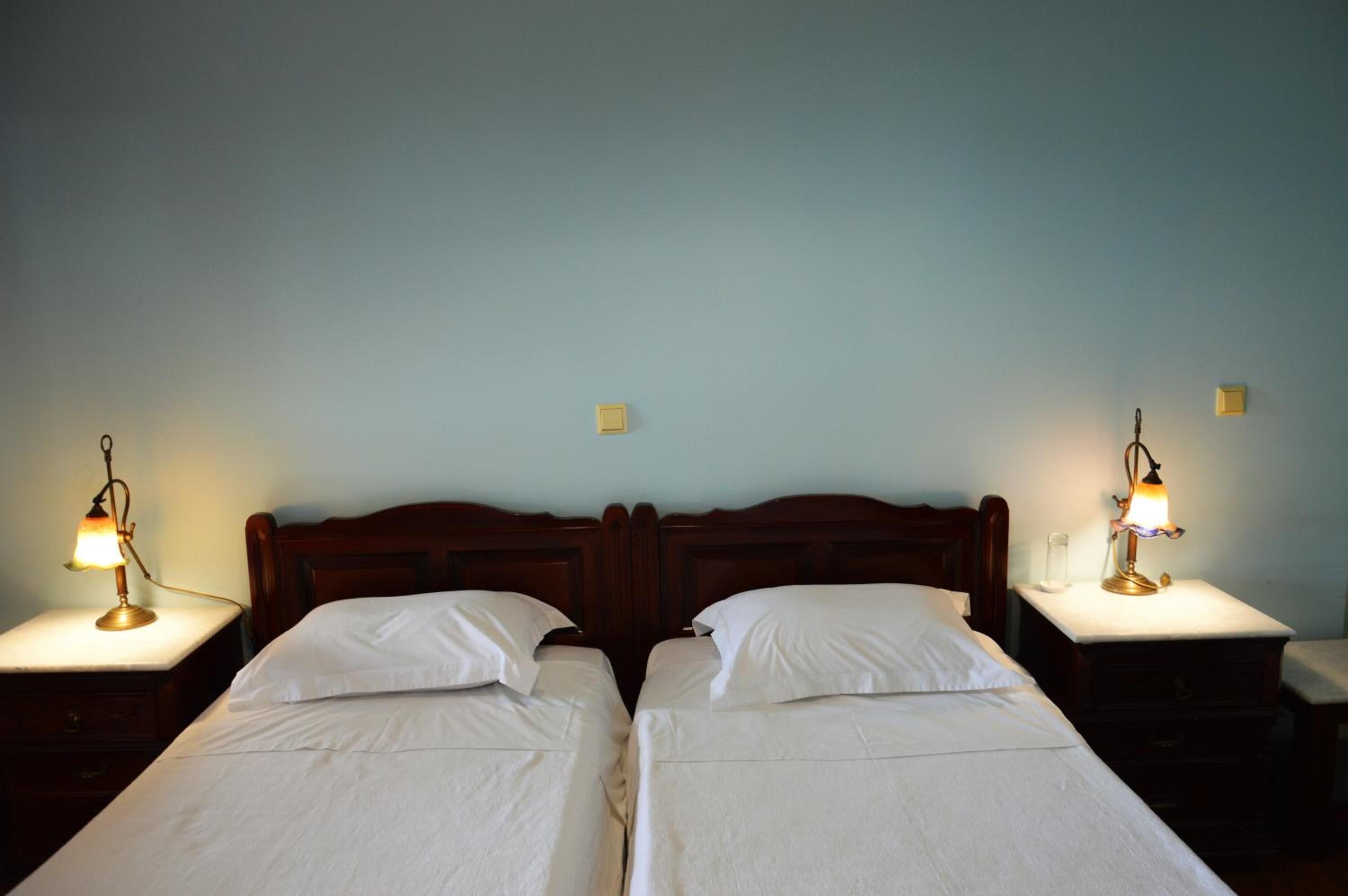 A double bed with two bedside tables, each with a lamp.