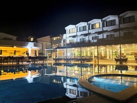 Un hotel con piscina, zona de estar al aire libre y bar.