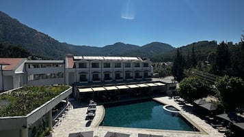 Una piscina techada, una piscina al aire libre de temporada, sombrillas