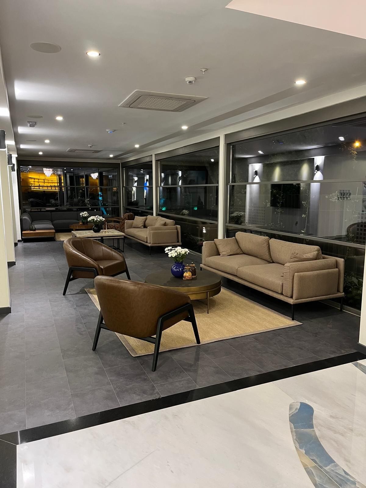 Una sala de estar moderna con sofás, sillones y una mesa de centro.