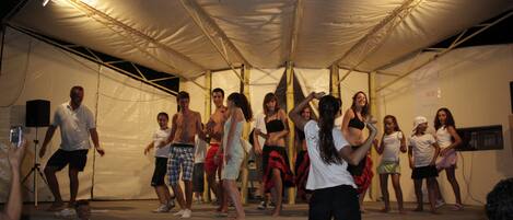 A group of people on a stage under a tent.