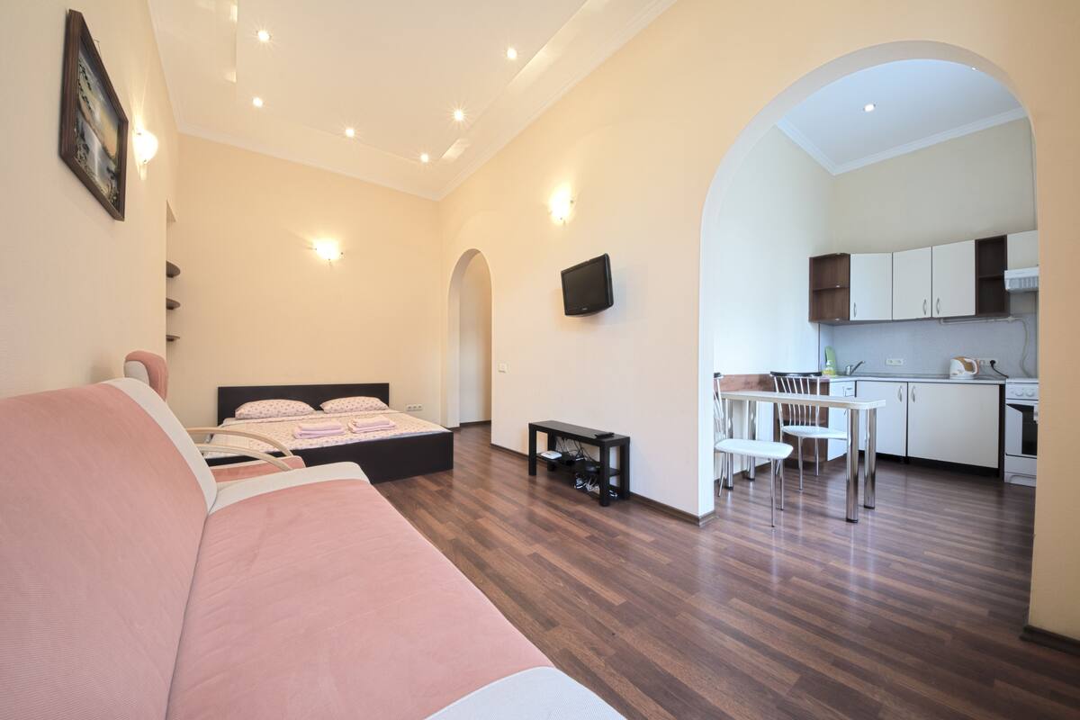 Un apartamento moderno con un dormitorio, sala de estar y cocina.
