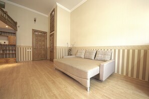 Quarto espaçoso com uma cama grande, piso de madeira, armário embutido e um lance de escadas.