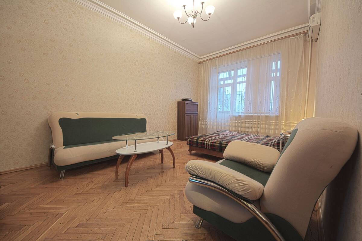 Una sala de estar con sofá, sillón y una mesita.